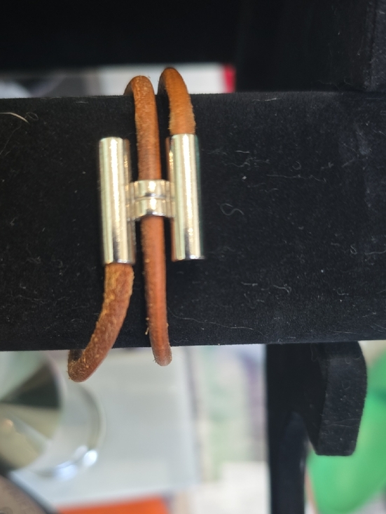 Hermès Tournis Tresse bracelet, which features a brown leather strap and an \